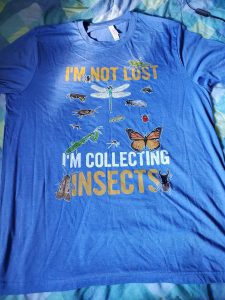 A blue shirt with insect images on it. Text on the shirt reads: I'm not lost I'm collecting insects.